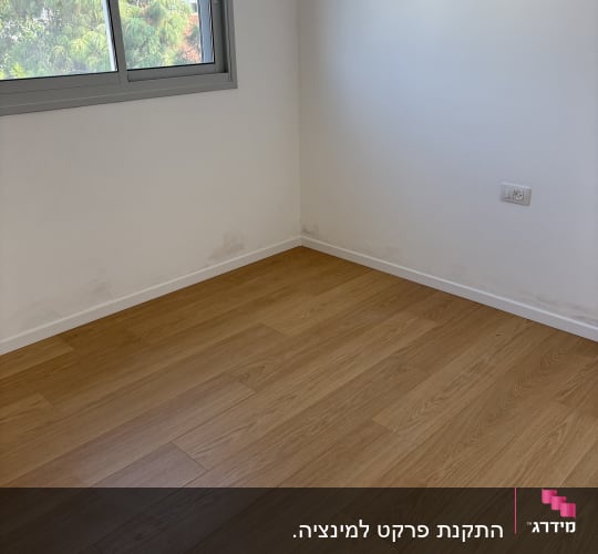רצפת פרקט בגוון עץ אלון בהיר מותקנת בחדר עם פנלים לבנים